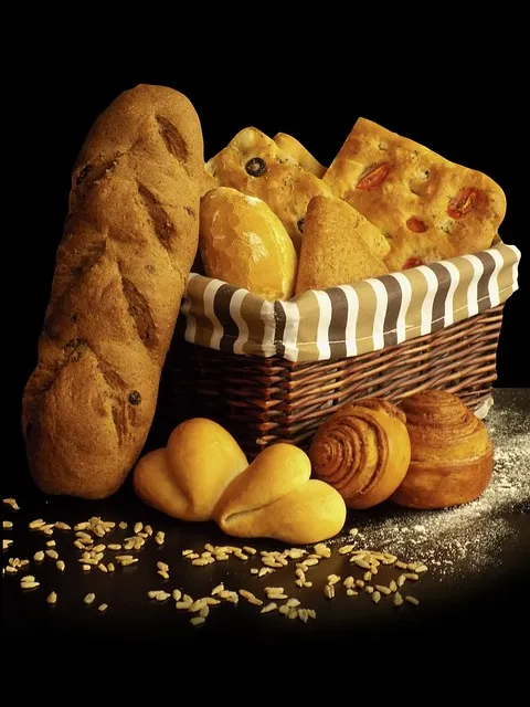 A loaf of artisan bread next to fresh croissants and muffins, showcasing a range of bakery products.