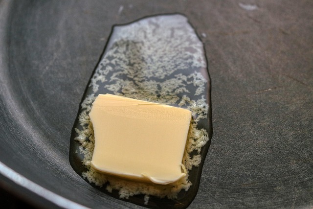 A stick of butter in a glass butter dish, ready for storage.